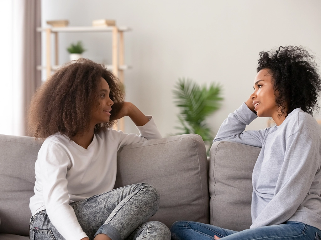 A young woman talking with her mother on the couch